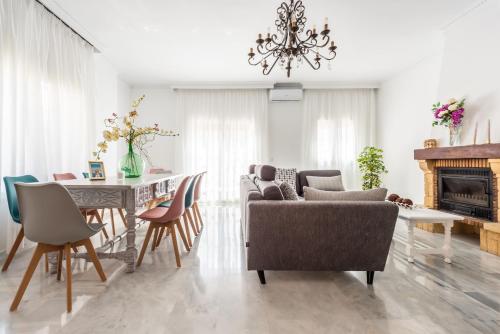 uma sala de estar com uma mesa e cadeiras e um lustre em Chalet Marbella Beach I em Marbella