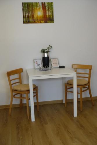 uma secretária branca com duas cadeiras e uma mesa com uma planta em Ruhige, modern eingerichtete 2 Zimmer Wohnung im Untergeschoss eines Zweifamilienhauses em Hildrizhausen