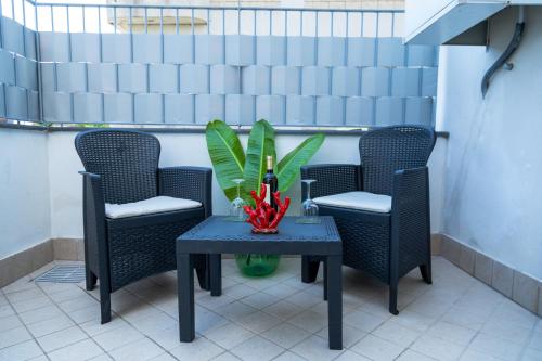 een tafel met stoelen en een plant op een patio bij Casa Corallium in Torre del Greco