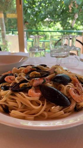 a plate of pasta with shrimp and seafood on a table at La Valle Verde hotel ristorante pizzeria in Zambrone