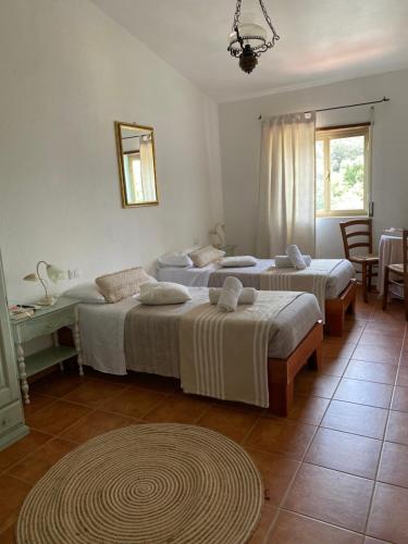 een slaapkamer met 2 bedden en een tafel bij B&B La Pitraia in Sant Antonio Di Gallura