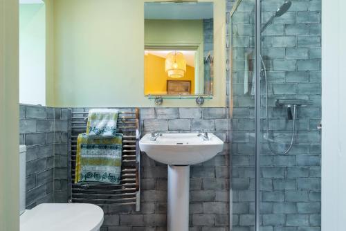 uma casa de banho com um lavatório e um chuveiro em The Manor Stables at Moyglare Manor em Maynooth