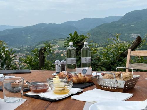 a wooden table with food and wine bottles on it at Il Torrione del Trebbia in Bobbio