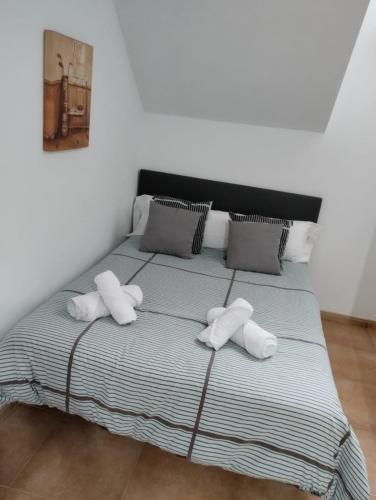a bed with three pillows on top of it at ALOJAMIENTO LOS DINOSAURIOS in Cuenca
