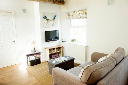 a living room with a couch and a television at OLD CHAPEL Hayton Cumbria CA89HR in Hayton