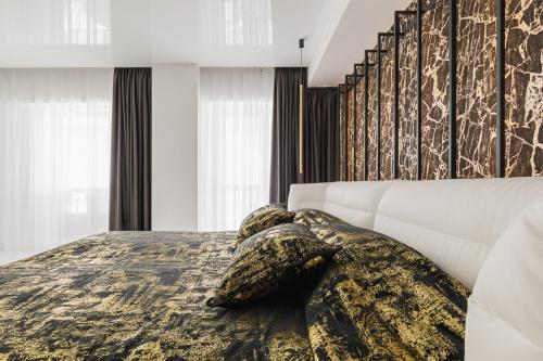 a bedroom with a bed with a blanket on it at Grand Supreme Jacuzzi Apartment by LIUKSAI in Klaipėda