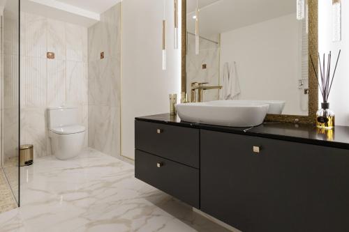 a bathroom with a sink and a toilet at Grand Supreme Jacuzzi Apartment by LIUKSAI in Klaipėda