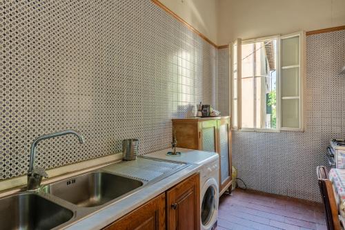 uma cozinha com um lavatório e uma máquina de lavar roupa em La casa di Ida em Pescia