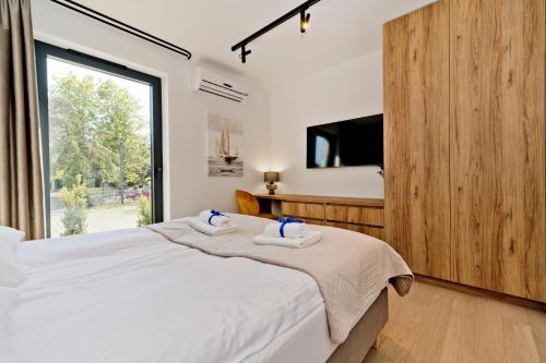 a bedroom with a large bed with two towels at Apartamenty Wydma & Las BlueApart in Jastarnia