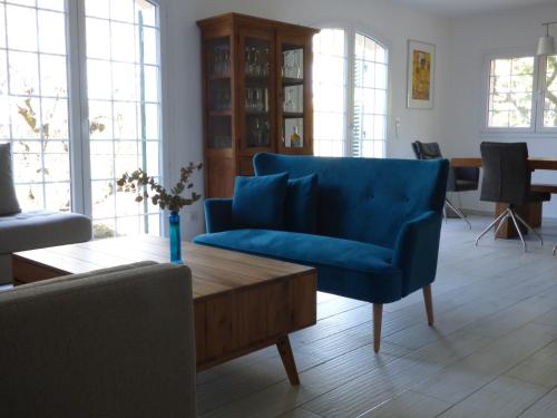 uma sala de estar com um sofá azul e uma mesa de centro em Apartment Fragonard mit geheiztem Pool und großer Privatterrasse em Châteauneuf