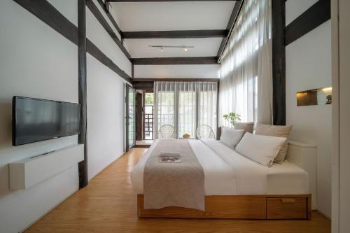a bedroom with a large bed and a tv at The Bivou Lijiang in Lijiang