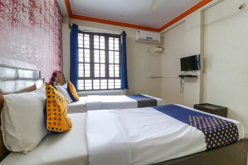 a bedroom with two beds and a window at SPOT ON Balaji Residency near Yeshwantupur Railway Station in Bengaluru