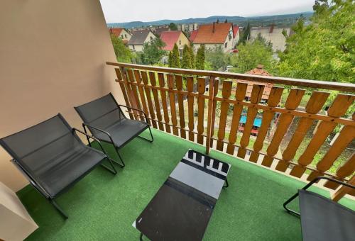 2 sillas y mesa en un balcón con vistas en Kopaszka Vendégház, en Sátoraljaújhely