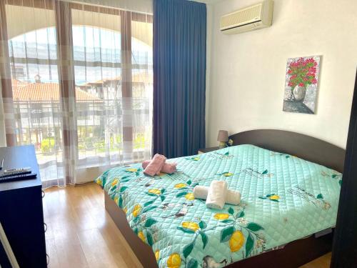 um quarto com uma cama com um edredão azul e uma janela em Apartment Marina beach k-s Triumph em Sveti Vlas