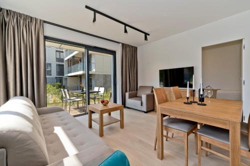 a living room with a couch and a table at Apartamenty Wydma & Las BlueApart in Jastarnia