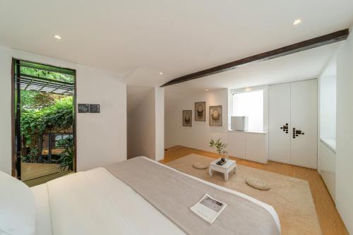 a bedroom with a large bed and a large window at The Bivou Lijiang in Lijiang