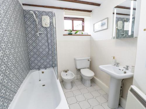 a bathroom with a tub and a toilet and a sink at Mordon Moor Cottage in Stockton-on-Tees