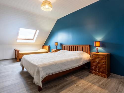 ein Schlafzimmer mit einem Bett und einer blauen Wand in der Unterkunft Holiday Home La Jolie Vague by Interhome in Beaubigny