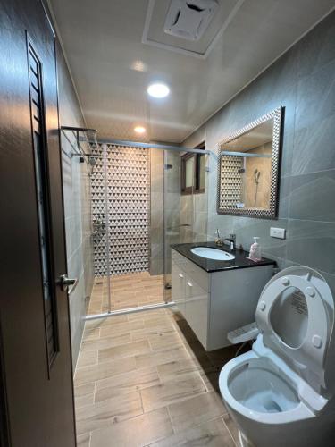 a bathroom with a shower and a toilet and a sink at Dongjin Bay B&B in Donggang