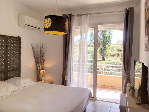 1 dormitorio con cama y ventana grande en T3 1 min de la plage et commerces d'agosta, en Porticcio