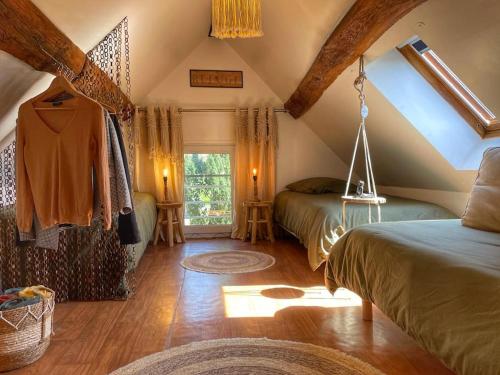a attic bedroom with two beds and a window at La longère du Ruet in Saint-Hilaire-Saint-Mesmin