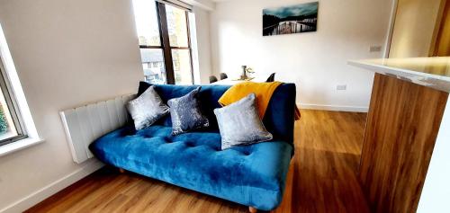 ein blaues Sofa mit Kissen darauf im Wohnzimmer in der Unterkunft Cliftonville Heights - 2 bed Home away from Home in Northampton