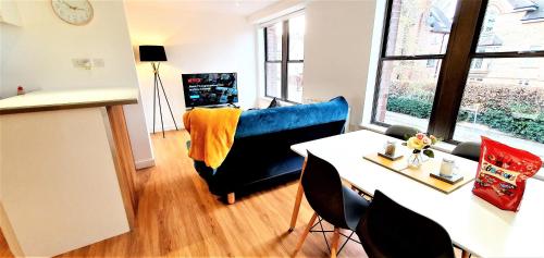 a living room with a table and a blue couch at Cliftonville Heights - 2 bed Home away from Home in Northampton