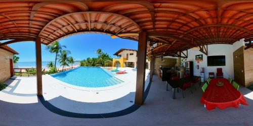 einen Pool in einem Gebäude mit einem Pavillon in der Unterkunft De Olho no Mar A única pousada de frente para o mar em Paracuru in Paracuru