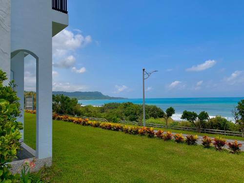 a garden with flowers and the ocean in the background at Taitung Blue Sea Villa in Chenggong