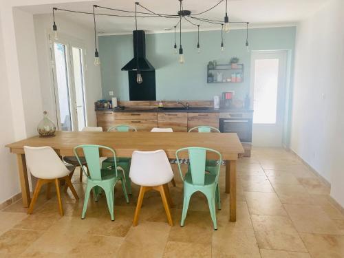 a dining room with a wooden table and chairs at La Maison d à côté 8 à 10 personnes in Carpentras