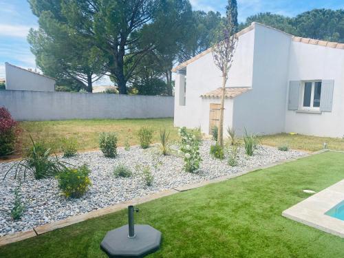 a garden with a small white house and a pool at La Maison d à côté 8 à 10 personnes in Carpentras