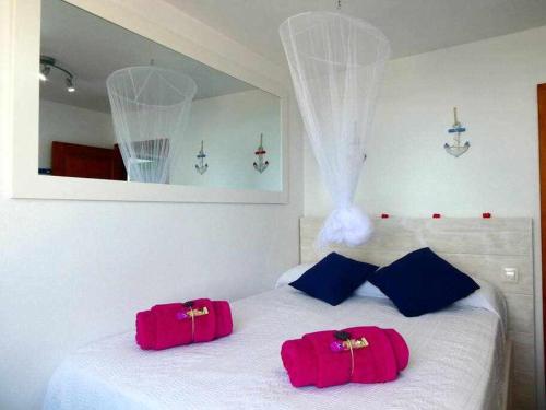 dos bolsas rojas sentadas encima de una cama blanca en Apartamento Vacacional Barquito en Playa Quemada, en Playa Quemada