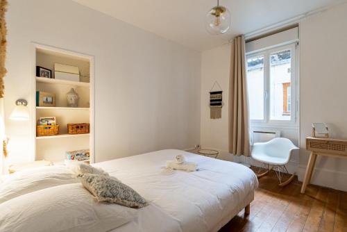 une chambre avec un lit avec un animal en peluche dessus dans l'établissement Les Ducs de Bourgogne, à Dijon