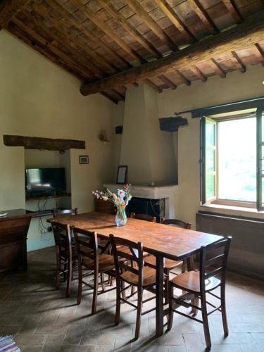 a dining room with a wooden table and chairs at Podere le Mulina in Castiglione dʼOrcia