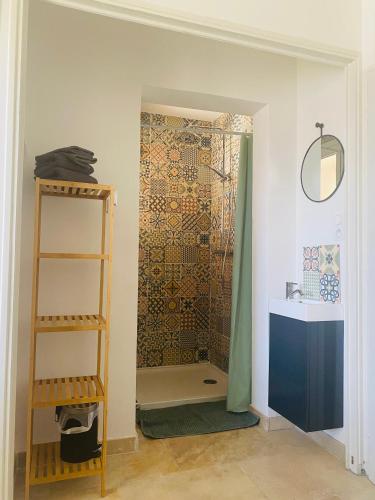 La salle de bains est pourvue d'une douche, de toilettes et d'une étagère. dans l'établissement La Maison d à côté 8 à 10 personnes, à Carpentras