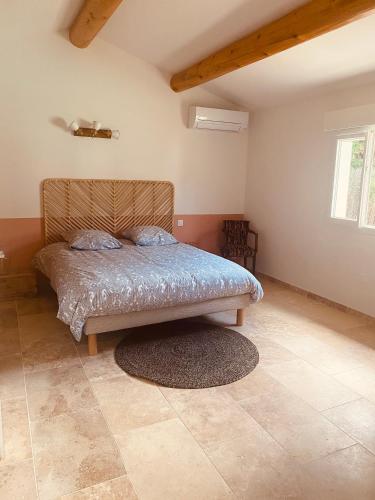 une chambre avec un lit dans le coin d'une pièce dans l'établissement La Maison d à côté 8 à 10 personnes, à Carpentras