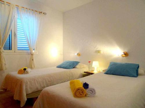 プラヤ・ケマダにあるCasa Descanso con Jacuzzi en Playa Quemadaのベッドルーム1室(ベッド2台、窓付)