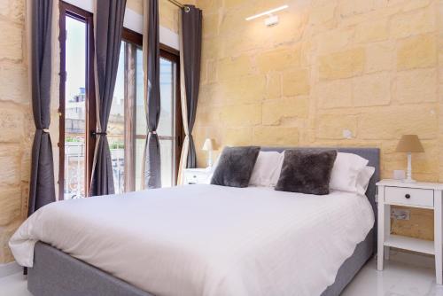 a bedroom with a large white bed and a window at Casa Deguara townhouse Rabat Malta in Rabat