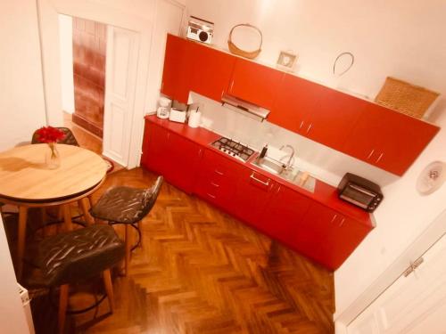 een keuken met rode kasten en een tafel en stoelen bij Casa Young&Jung in Sibiu