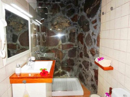 a bathroom with a sink and a stone wall at Casa Yuno en La Asomada in La Asomada
