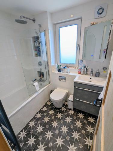 e bagno con servizi igienici, lavandino e doccia. di Cosy guest room in a family home a Edimburgo