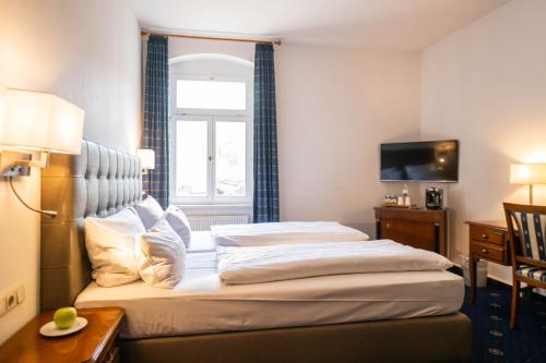a hotel room with a bed and a window at Historische Spitzgrundmühle in Coswig