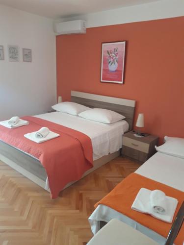 2 camas en una habitación con paredes de color naranja en Apartments Smiljana Mucić, en Makarska