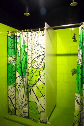 a green bathroom with a shower with a shower curtain at Green Cube Capsule Hostel in Sofia