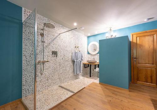 a bathroom with a shower with a blue wall at BRU-LAGOON Guesthouse in Bruges