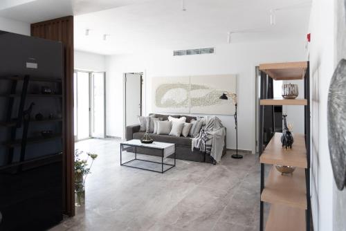 a living room with a couch and a table at Golden Bay luxury villas and suites in Chrissi Akti