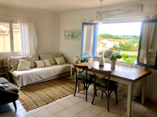 un salon avec une table et un canapé dans l'établissement 1Bed Cottage Sleeps 4- Sea Views Balcony Parking, à Mèze