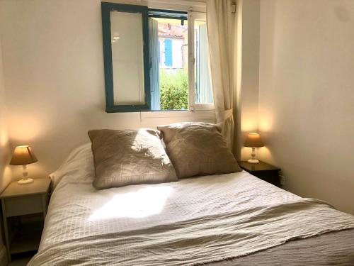 une chambre avec un lit avec deux lampes et une fenêtre dans l'établissement 1Bed Cottage Sleeps 4- Sea Views Balcony Parking, à Mèze