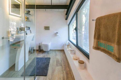 a bathroom with a toilet and a sink and a mirror at Villa Tarifa Lodge in Tarifa