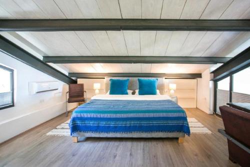 a bedroom with a large bed with blue pillows at Villa Tarifa Lodge in Tarifa